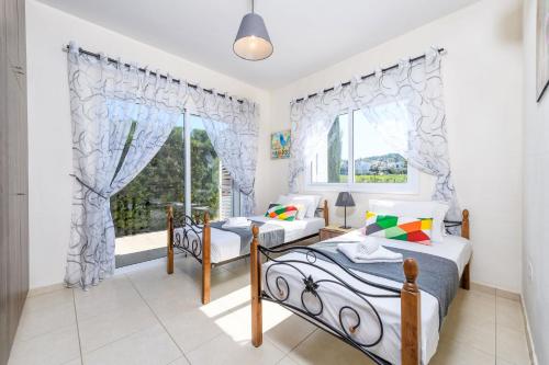 1 Schlafzimmer mit 2 Betten und einem Fenster in der Unterkunft Sunset Villa Protaras in Protaras