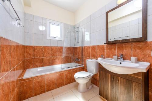 ein Badezimmer mit einem WC, einem Waschbecken und einer Badewanne in der Unterkunft Sunset Villa Protaras in Protaras