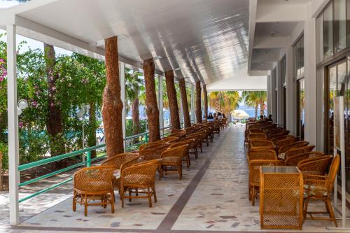 a row of chairs and tables on a balcony with trees at Hotel Grand Efe in Ozdere