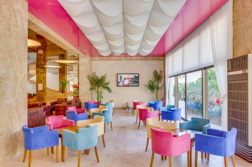 a dining room with colorful chairs and tables at Hotel Grand Efe in Ozdere