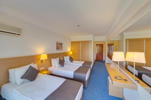 a hotel room with two beds and a couch at Hotel Grand Efe in Ozdere