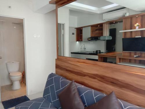 Il comprend un salon avec un canapé bleu et une cuisine. dans l'établissement Raja Apartemen Jarrdin Type 33, à Bandung