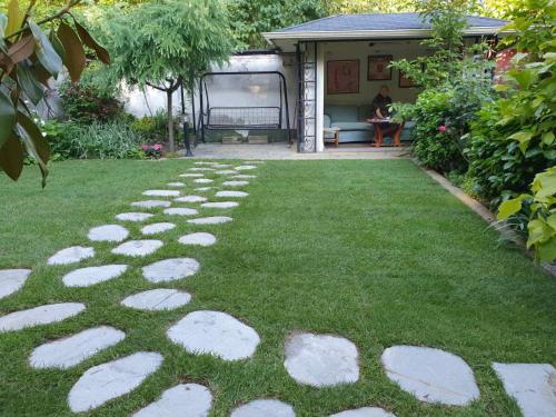 a garden with stepping stones on the grass at R & R Apartments in Sofia