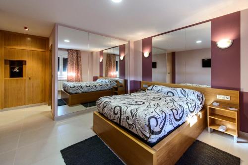 1 dormitorio con 1 cama grande y espejo en Motel Cancun Avilés, en Iboya