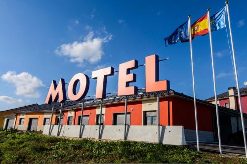 a motel sign on top of a building with two flags at Motel Cancun Avilés in Iboya