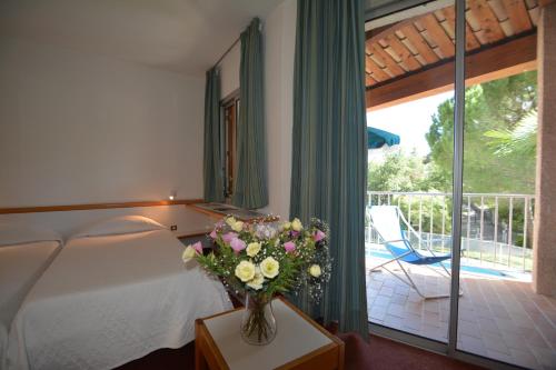 ein Schlafzimmer mit einem Bett und einer Vase aus Blumen auf einem Tisch in der Unterkunft Les Hauts De Greoux in Gréoux-les-Bains