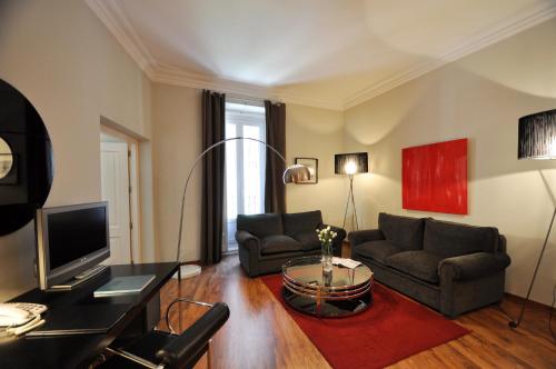 a living room with two couches and a television at Suite Prado in Madrid