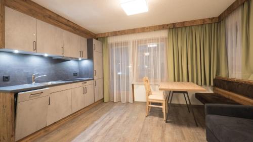 a kitchen with a sink and a table in a room at Central Hotel & Apart mit Landhaus Central in Fügen