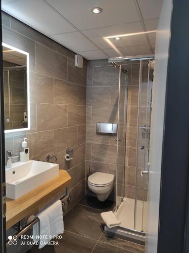 a bathroom with a toilet and a sink and a shower at Akzent City-Hotel Kleve in Kleve