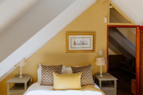 a bedroom with a white bed with two night stands at Skip Skop in Paternoster