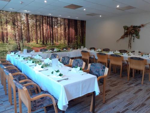a room with tables and chairs with trees in the background at Naturhotel Lindenhof in Rechenberg-Bienenmühle