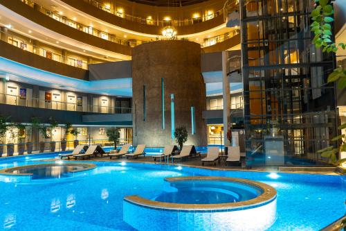 a large swimming pool in a hotel lobby at Doğa Thermal Health & Spa in Pamukkale