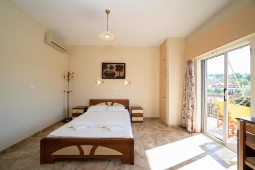 a bedroom with a bed and a large window at Lorenzo House Apartments in Lassi