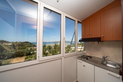 a kitchen with windows with a view of the ocean at Lorenzo House Apartments in Lassi