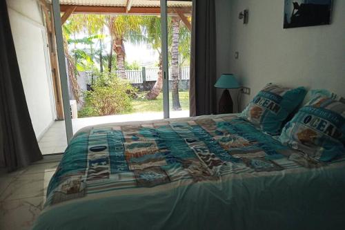 a large bed in a bedroom with a window at Maison F3 mitoyenne avec piscine partagée et jardin privatif - Résidence Plaiz'Anse in Petite Île