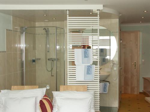 a bathroom with a shower and two pillows at Hotel Alpina nature-wellness in Wenns