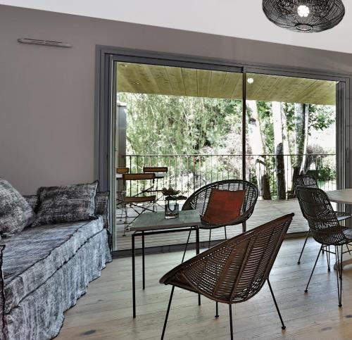 a living room with a couch and a table and chairs at Les Glycines - Hôtel & Spa - Teritoria in Les Eyzies-de-Tayac