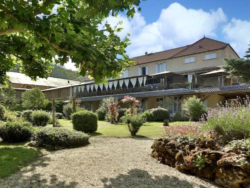 a garden in front of a large building at Les Glycines - Hôtel & Spa - Teritoria in Les Eyzies-de-Tayac
