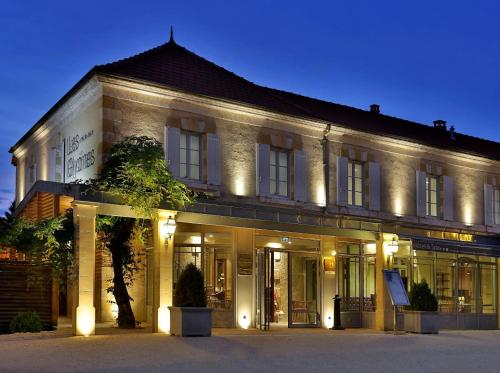 a large building with lights in front of it at Les Glycines - Hôtel & Spa - Teritoria in Les Eyzies-de-Tayac