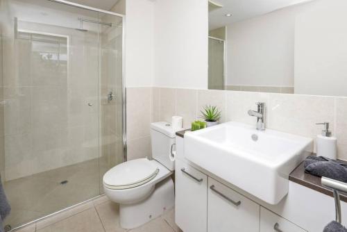 a bathroom with a toilet and a sink and a shower at Pool View City Centre Apartment 206 in Cairns