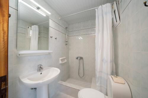ein Bad mit einem Waschbecken, einem WC und einer Dusche in der Unterkunft Lorenzo Hotel in Lassi