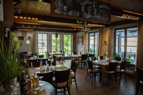een eetkamer met tafels, stoelen en ramen bij Jana´s Ferienappartements in Plau am See