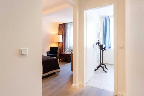 a view of a room with a bed and a desk at Romantik Hotel Walhalla in Osnabrück