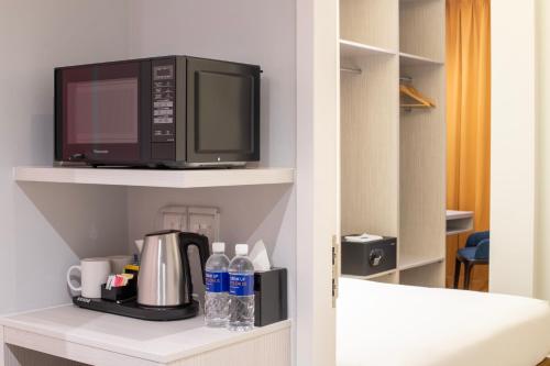 a microwave oven sitting on top of a shelf at Holiday Inn Express & Suites Johor Bahru by IHG in Johor Bahru