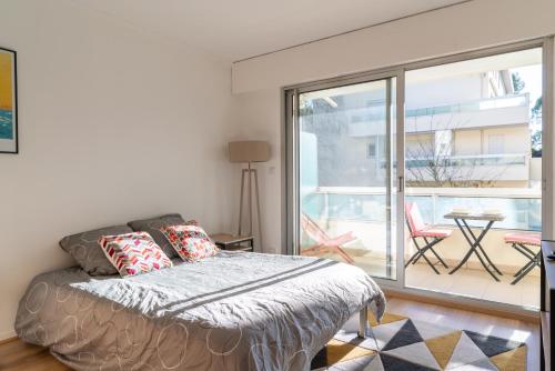 une chambre avec un lit et une porte coulissante en verre dans l'établissement Maia, à La Baule