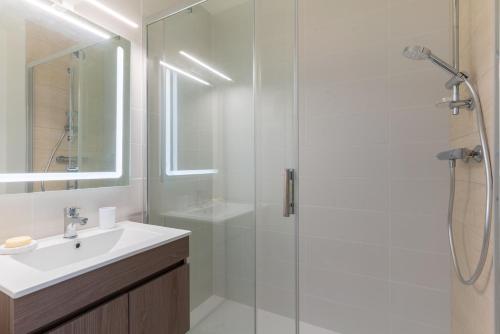une salle de bain avec une douche en verre et un lavabo dans l'établissement Maia, à La Baule