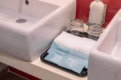 a bathroom sink with a cell phone sitting in a sink at Holiday Inn Express & Suites Johor Bahru by IHG in Johor Bahru