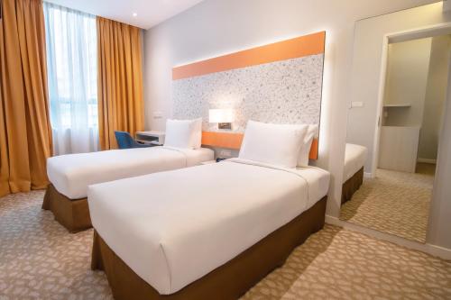 a hotel room with two beds and a desk at Holiday Inn Express & Suites Johor Bahru by IHG in Johor Bahru