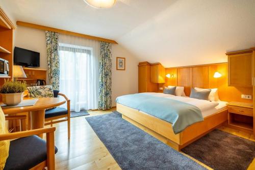 a hotel room with a bed and a desk at Sportpension Bergblick in Wagrain