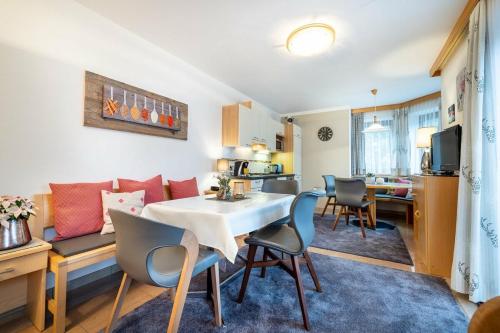 a kitchen and a living room with a table and chairs at Sportpension Bergblick in Wagrain