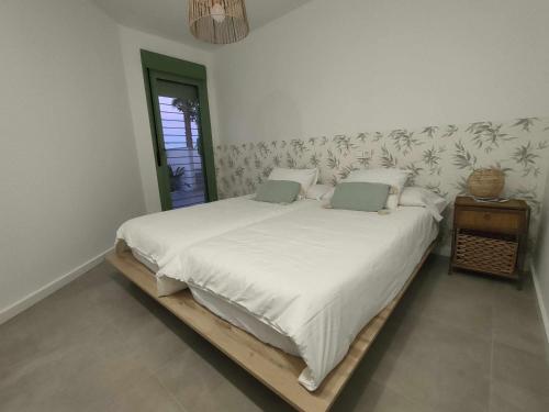 ein Schlafzimmer mit einem großen Bett mit weißer Bettwäsche in der Unterkunft Apartamento La Invencible Mojacar 1ª Línea Playa in Mojácar