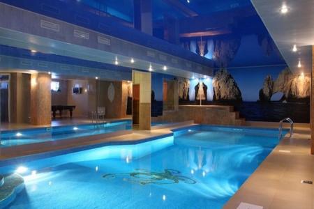a large blue swimming pool in a hotel at Lazurny Bereg Hotel in Tyumen