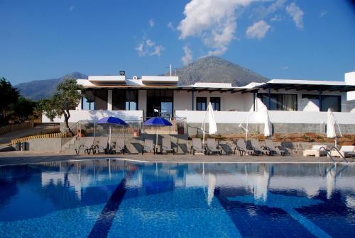 a building with a swimming pool in front of a house at Samothraki Beach Boutique Hotel in Makrilies