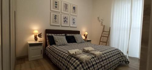 ein Schlafzimmer mit einem Bett mit einer karierten Decke und zwei Lampen in der Unterkunft Casa Fronte del porto in Bari