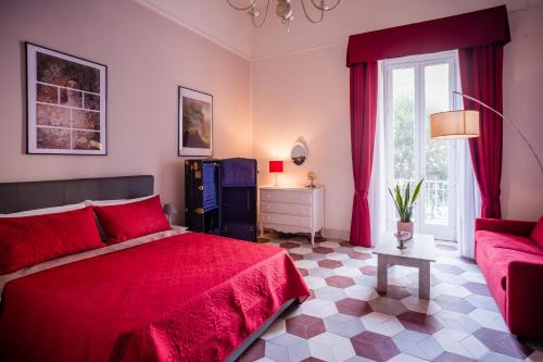 ein Schlafzimmer mit einem roten Bett und einer Couch in der Unterkunft ForiArt Relais in Neapel