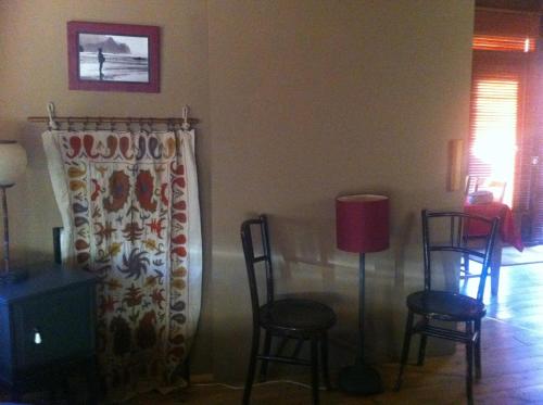 a living room with two chairs and a table and a lamp at Las Horas Perdidas in Manzanares el Real