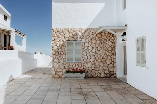 a building with a stone wall and a window at As it is in Heaven in Paternoster