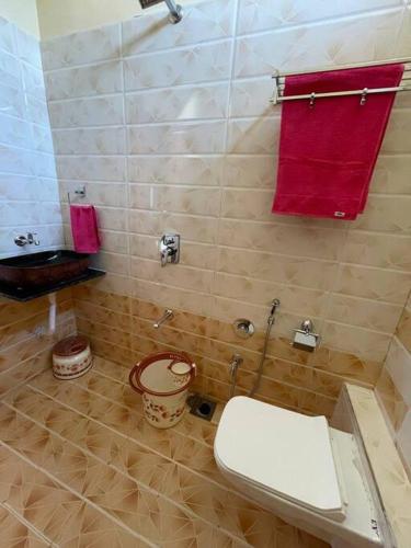 a bathroom with a toilet and a red towel at Suman Madhu Mansion in Nānodra