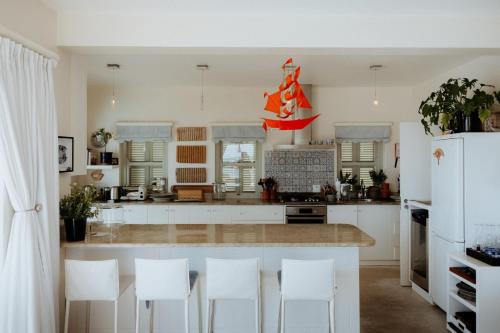 a kitchen with white cabinets and white appliances at As it is in Heaven in Paternoster