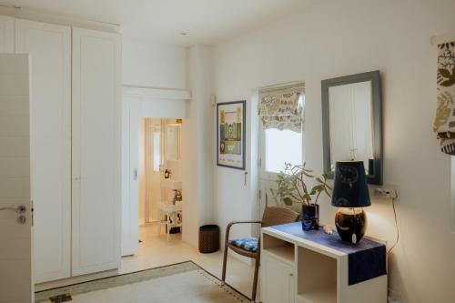 a room with a desk with a lamp on it at As it is in Heaven in Paternoster