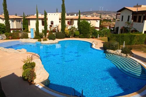 a large blue swimming pool in a yard at Aphrodite Hills Rentals - Junior Villas in Kouklia