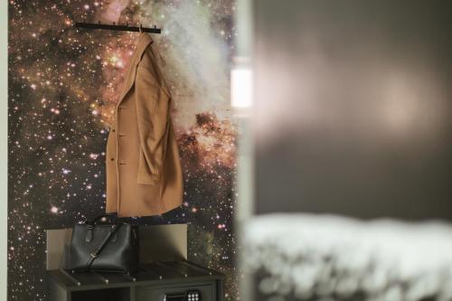 a coat hanging on a pole next to a table at Holiday Inn - the niu Star Sindelfingen by IHG in Sindelfingen