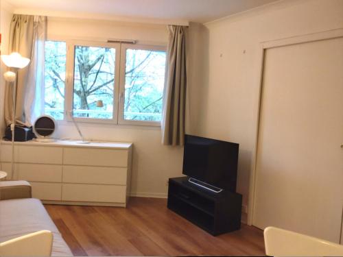 - une chambre avec une télévision, un lit et une fenêtre dans l'établissement 7 min walk Metro, ApartHotel, La Défense, à Courbevoie