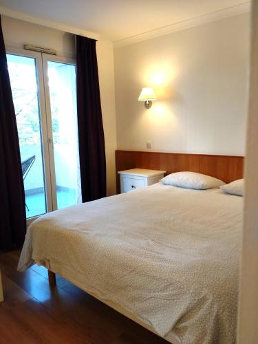 une chambre avec un grand lit et une fenêtre dans l'établissement 7 min walk Metro, ApartHotel, La Défense, à Courbevoie