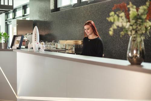 a woman standing behind a counter in a kitchen at Holiday Inn - the niu Star Sindelfingen by IHG in Sindelfingen