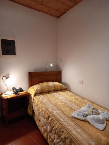 a bedroom with a bed and a table with a telephone at Hotel Italia in Sacile